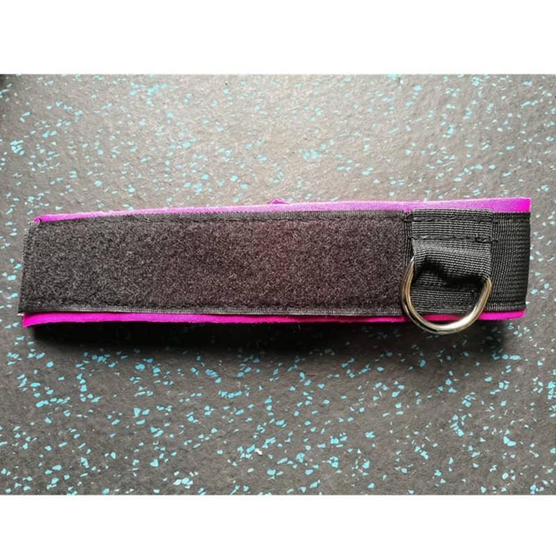 Black and pink strap with a metal ring on a speckled gray surface