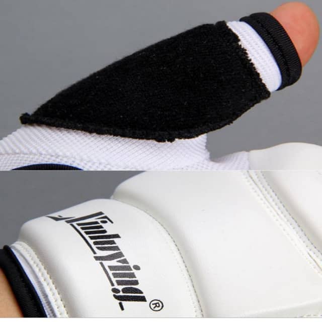 Close-up of a white boxing glove with black wrist wrap and brand logo on a gray background