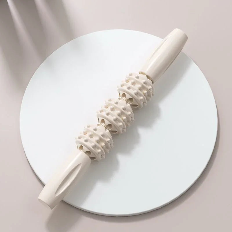 Beige spiky muscle roller stick for massage therapy and fitness recovery on neutral background