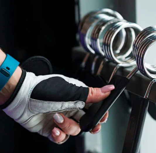 Gloved hand selecting gym clamp from fitness equipment rack