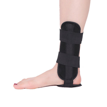 Black ankle support brace on a person's foot against a white background
