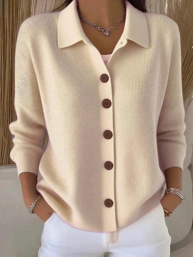 Beige cardigan with brown buttons worn by a person, against a neutral background