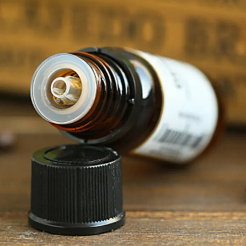 Bottle cap and neck of a brown glass bottle with a white label on a wooden surface.