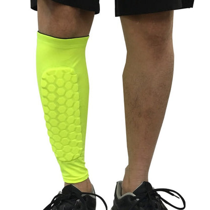 Bright yellow shin guard on a person's leg against a white background