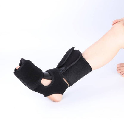 Adjustable black ankle and foot support brace on a person's leg for injury recovery