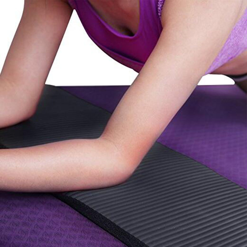 Person using a black and purple exercise mat on a white background