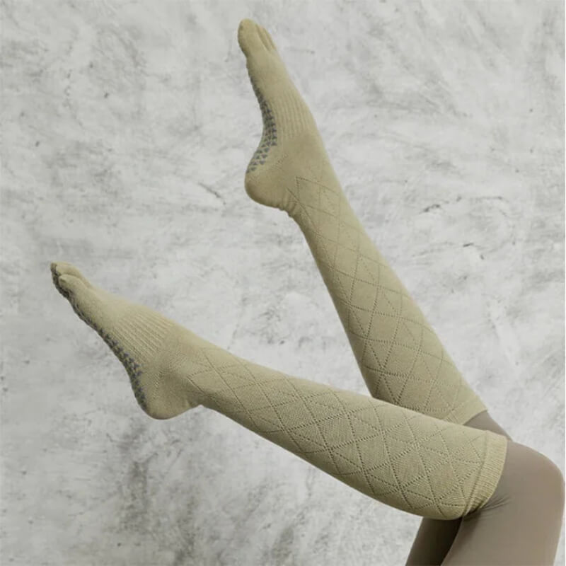 Beige knee-high compression socks with textured grip soles against a light background