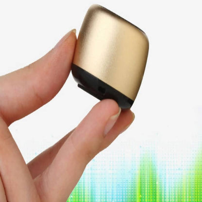 Gold and black electronic device held between fingers with a colorful blurred background