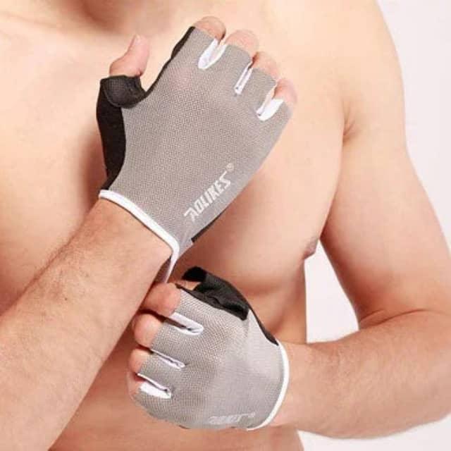 Man wearing gray fingerless workout gloves for gym or fitness training