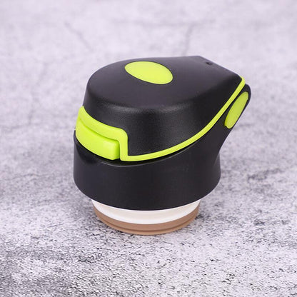 Compact black and green handheld fitness massage tool on a textured gray surface
