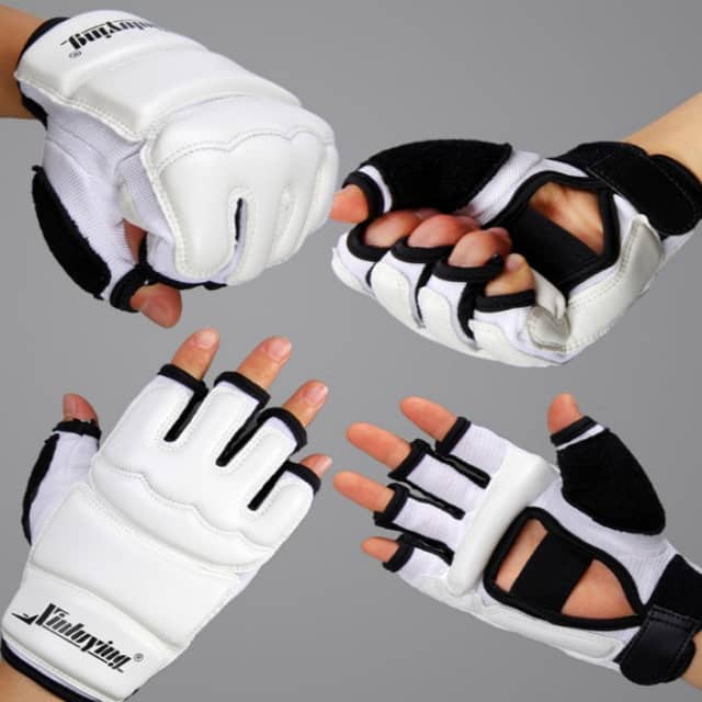 Pair of white and black gloves with cut-out design on a gray background
