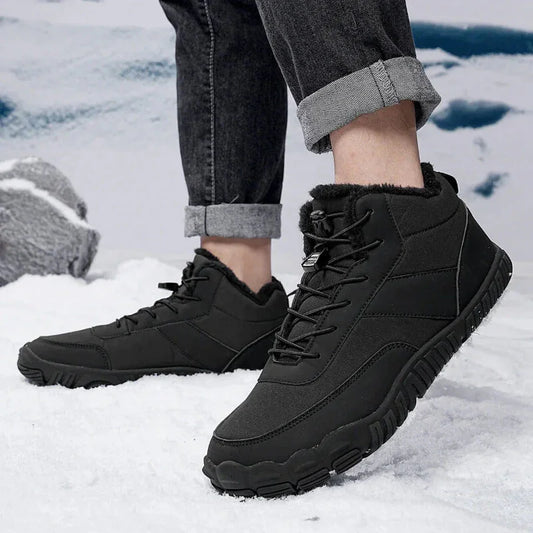 Black winter hiking boots with fur lining worn outdoors on snowy ground
