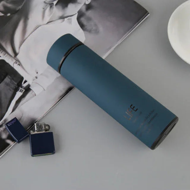 matte blue insulated water bottle on table with black and white magazine and blue lighter