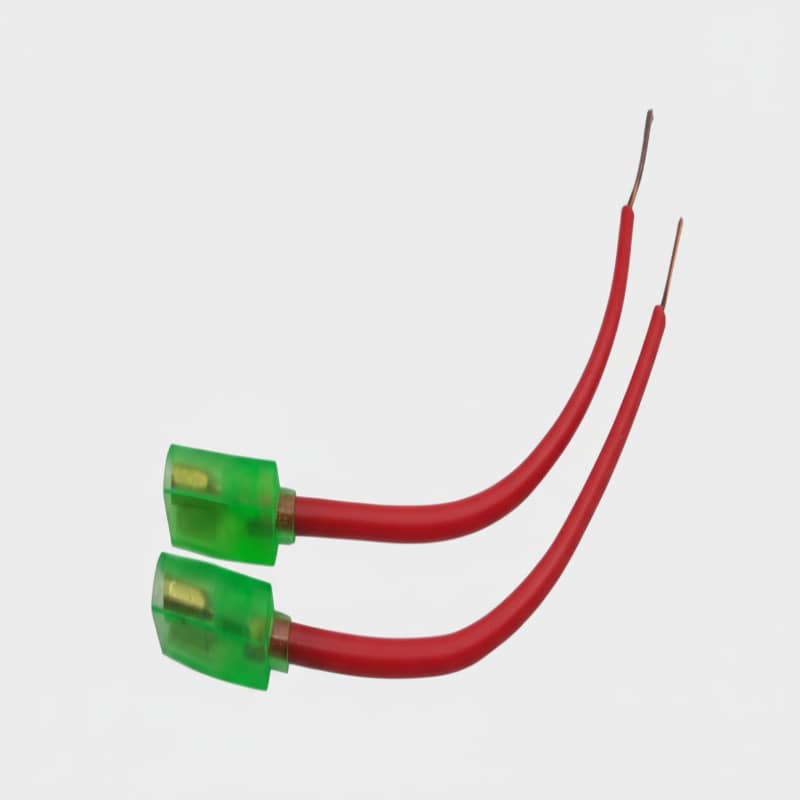 Two red wires with green connectors on a white background