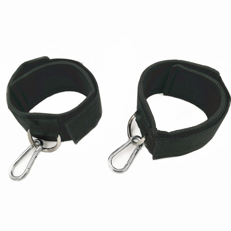 Two black wrist cuffs with metal hooks on a white background