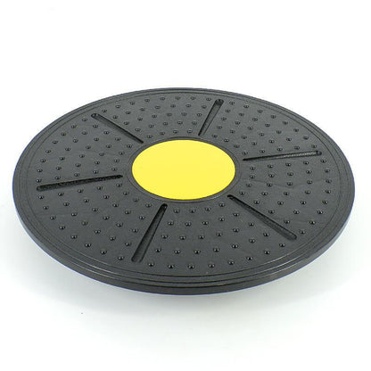 Black exercise disc with a yellow center on a white background