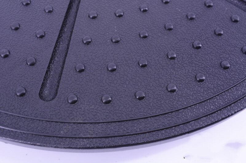 Close-up of a textured black mat with raised dots on a white background