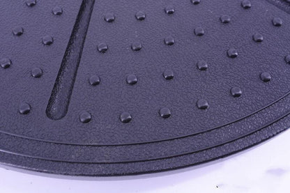 Close-up of a textured black mat with raised dots on a white background