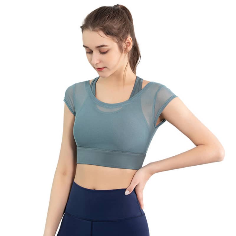 Woman wearing blue mesh short sleeve workout top and high-waisted fitness leggings