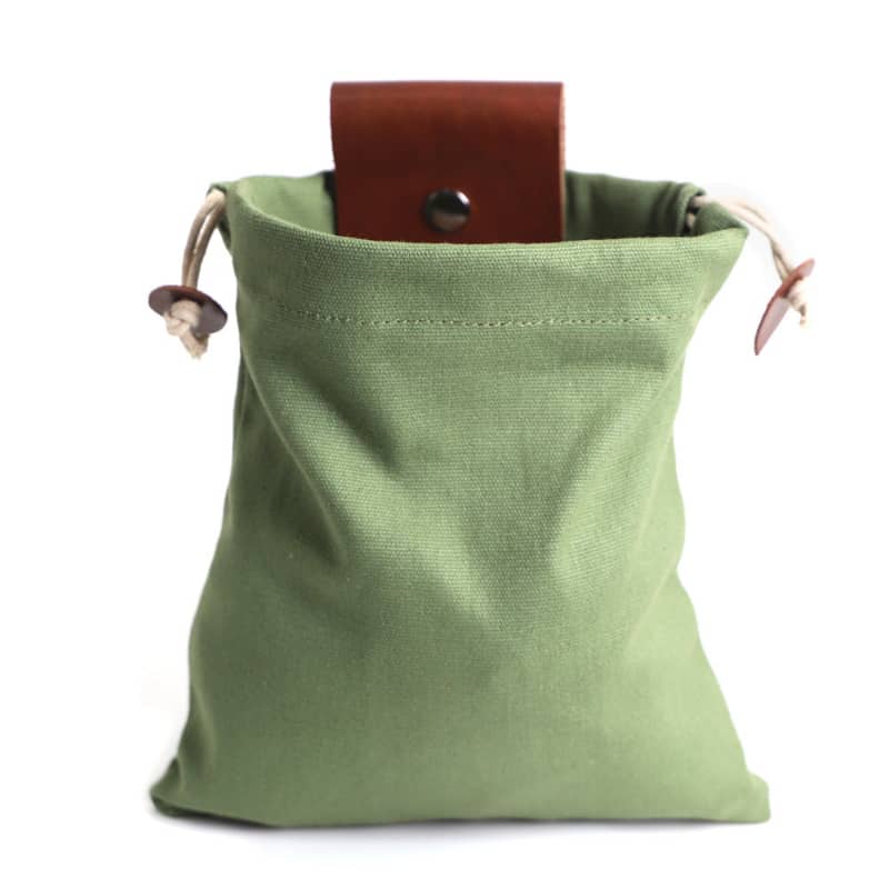 Green drawstring pouch with brown leather pull on a white background
