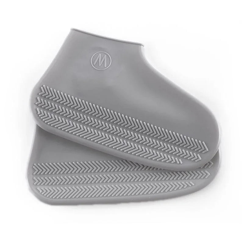 Gray silicone shoe covers with textured sole on a white background