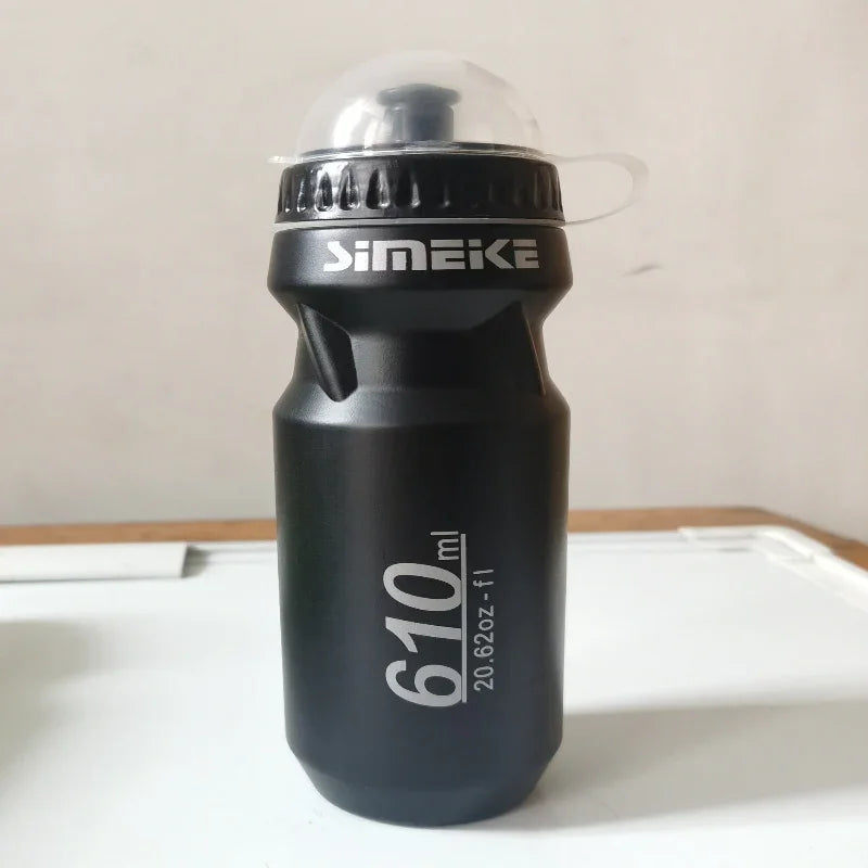 Black 610ml sports water bottle with flip-top cap on a table, ideal for fitness and outdoor use