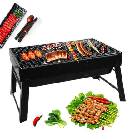 Portable charcoal grill with assorted meat, skewers, and vegetables on a white background