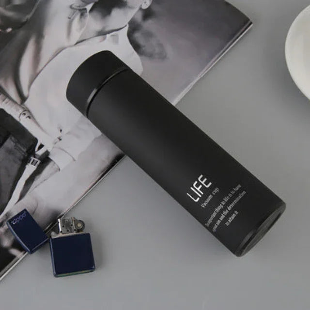 Sleek black insulated fitness water bottle labeled LIFE on a gray surface with magazine and lighter