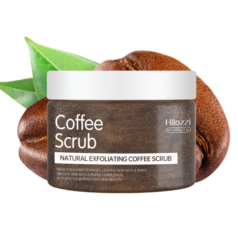 Jar of coffee scrub with coffee beans and green leaves on a white background