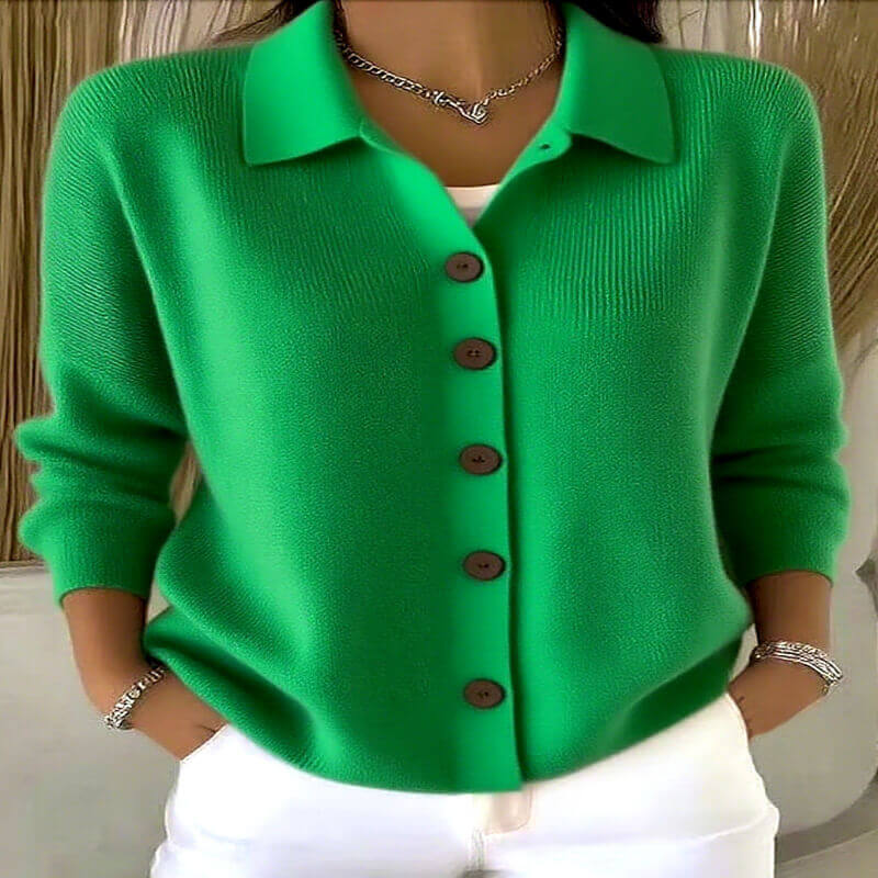 Green cardigan with brown buttons worn by a person, against a neutral background