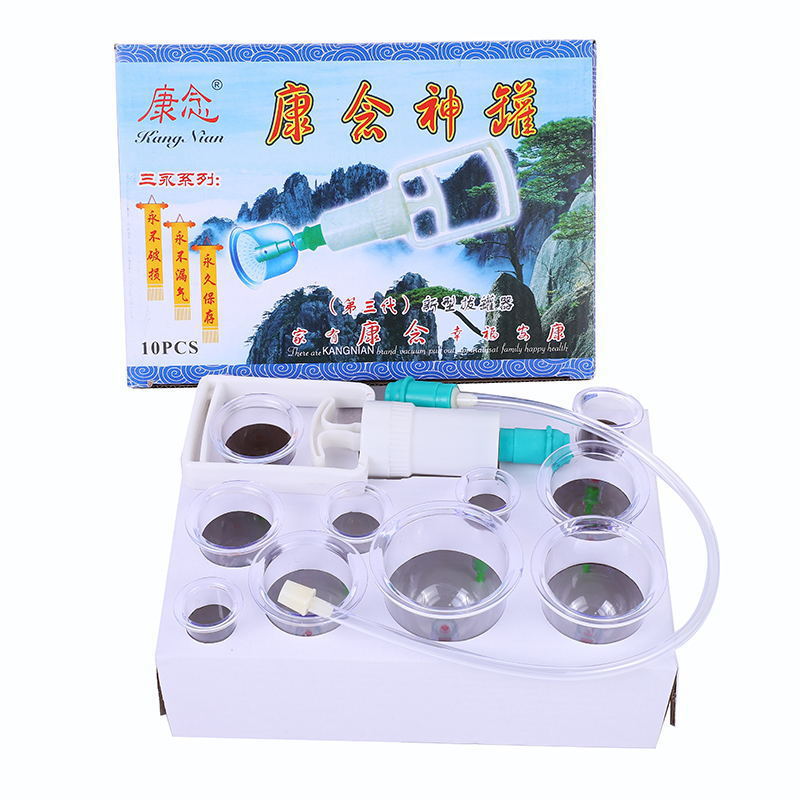 White electronic device with transparent lid, containing small round containers, in front of a colorful box with text and images.