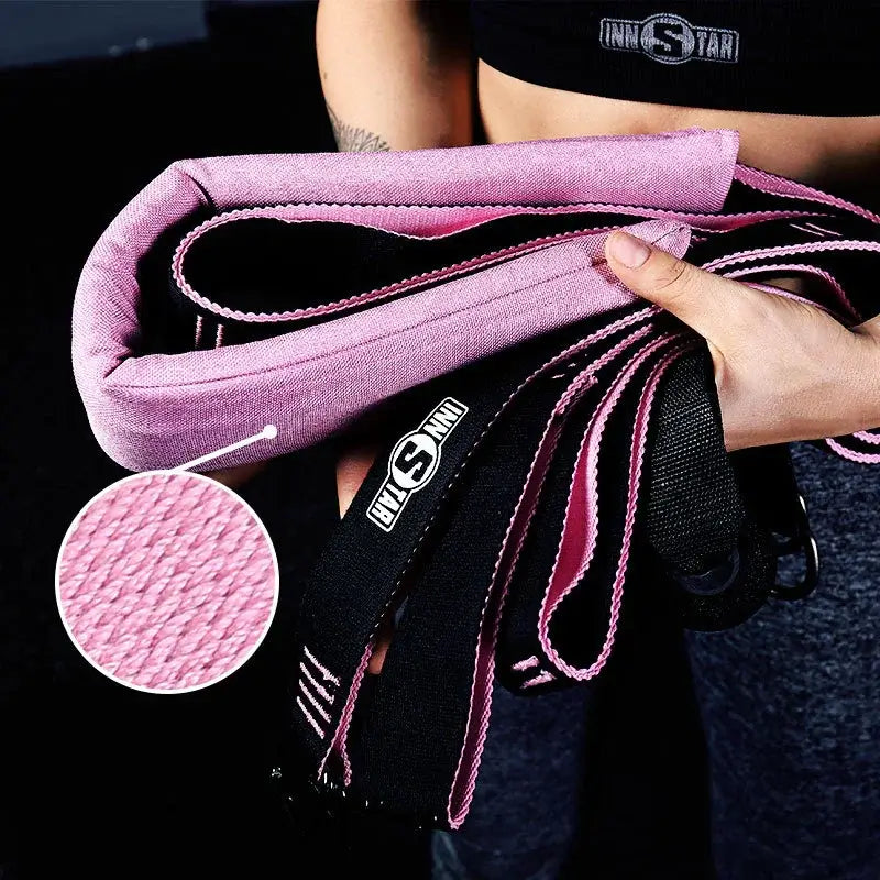 Person holding pink and black resistance bands with close-up of fabric texture, fitness gear