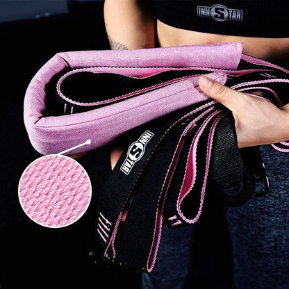 Person holding pink and black resistance bands with close-up of fabric texture, fitness gear