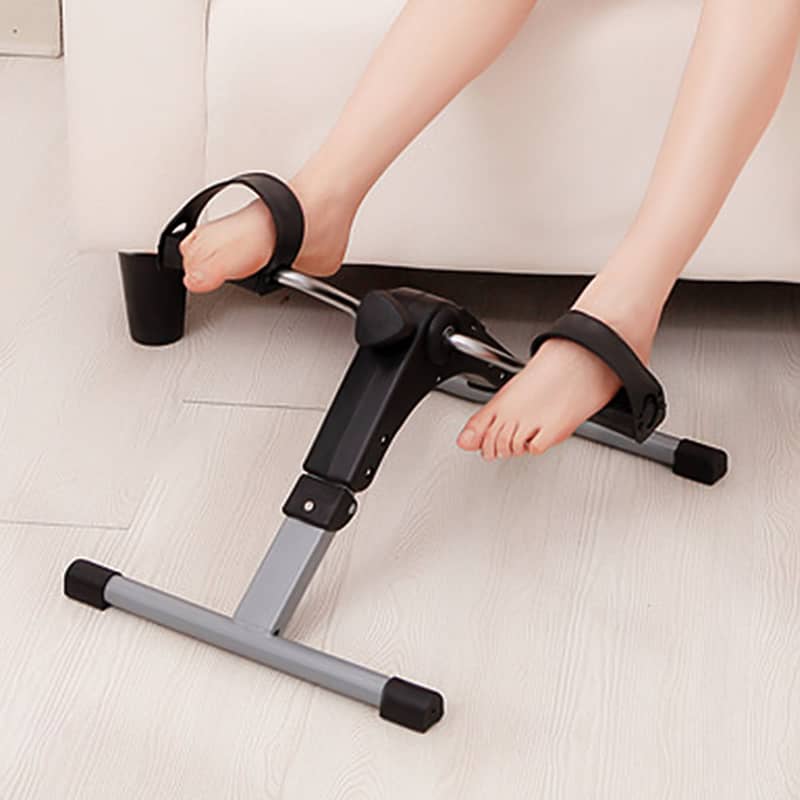 Person using a foot exercise device on a light-colored floor.