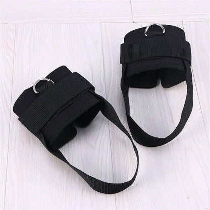 Pair of black ankle straps on a light wooden floor