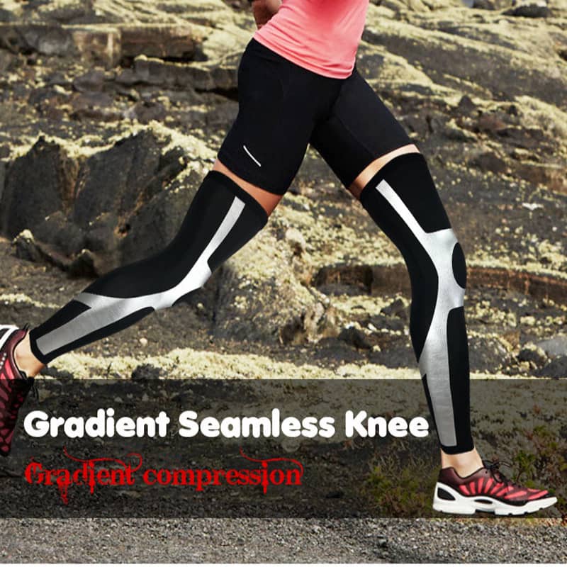 Person wearing black gradient compression knee sleeves on a rocky terrain