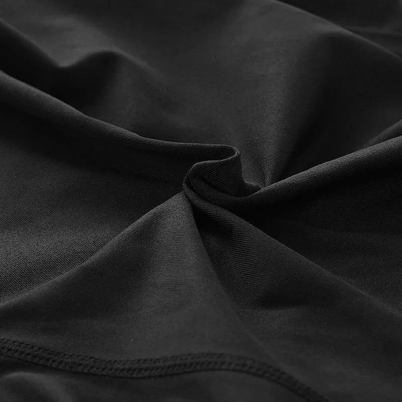 Close-up of black stretch fabric with detailed texture and seam, ideal for fitness apparel