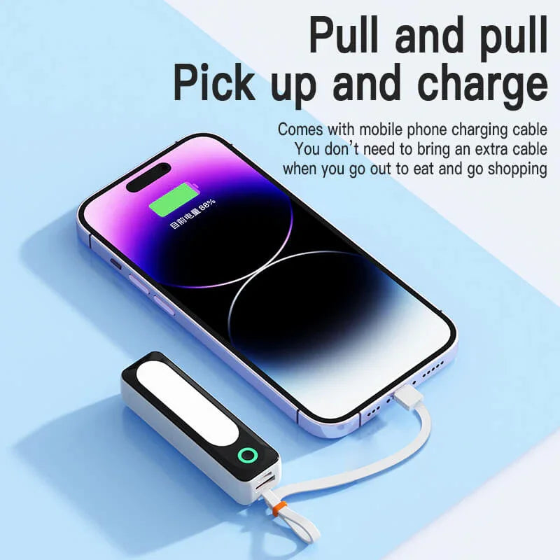 Portable mini power bank charging smartphone with built-in cable on light blue background