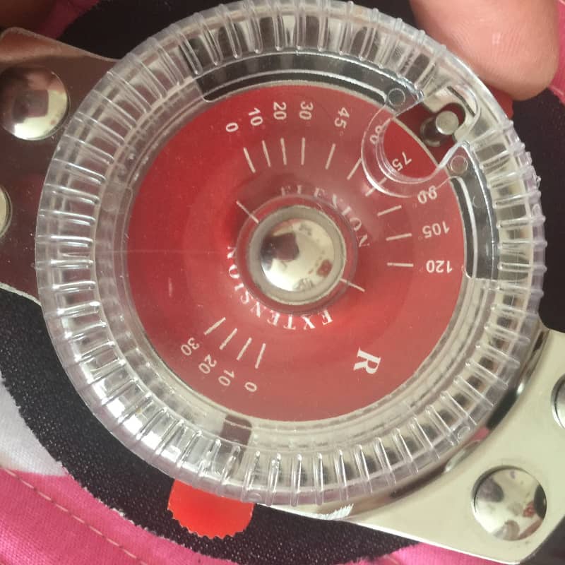 Close-up of a red and silver measuring device with visible brand name.