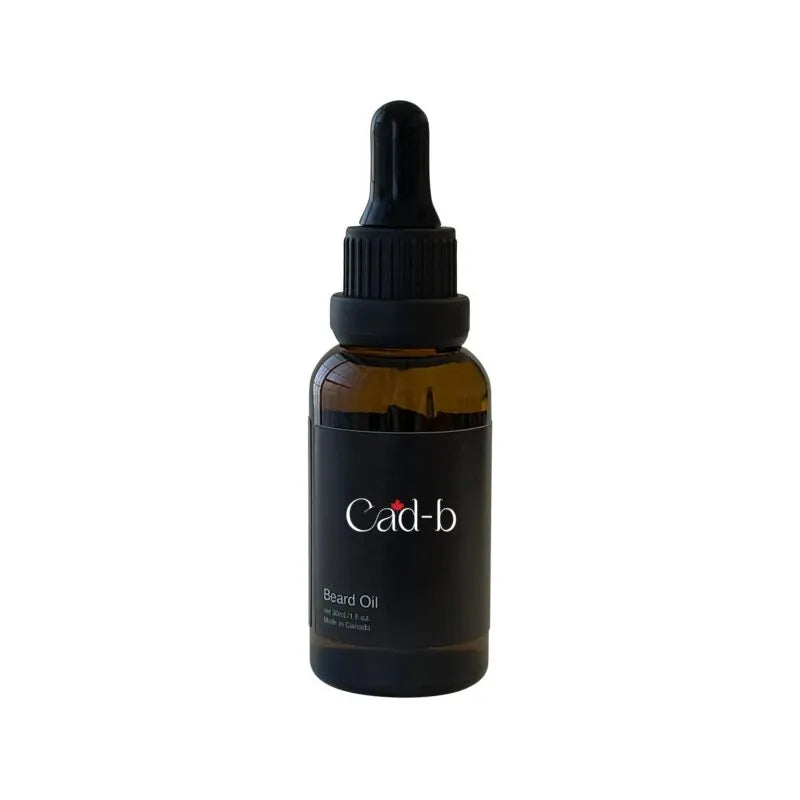 A dark amber glass dropper bottle of Cad-b Beard Oil with a black dropper cap and black label, shown on a plain white background.