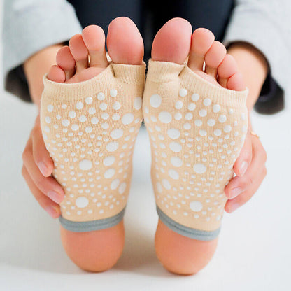Beige socks with white polka dots held up to show sole design.