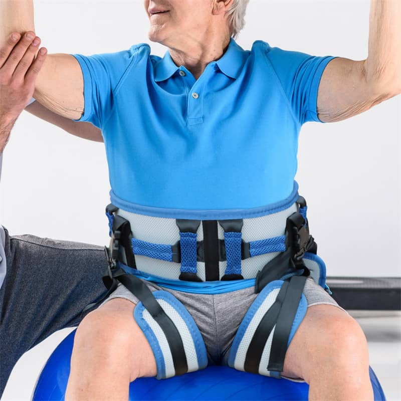 Person wearing a blue shirt and gray shorts with a back brace, sitting on a blue chair.
