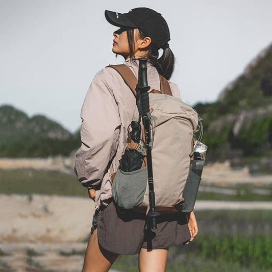 Person with a backpack and walking stick in a natural setting