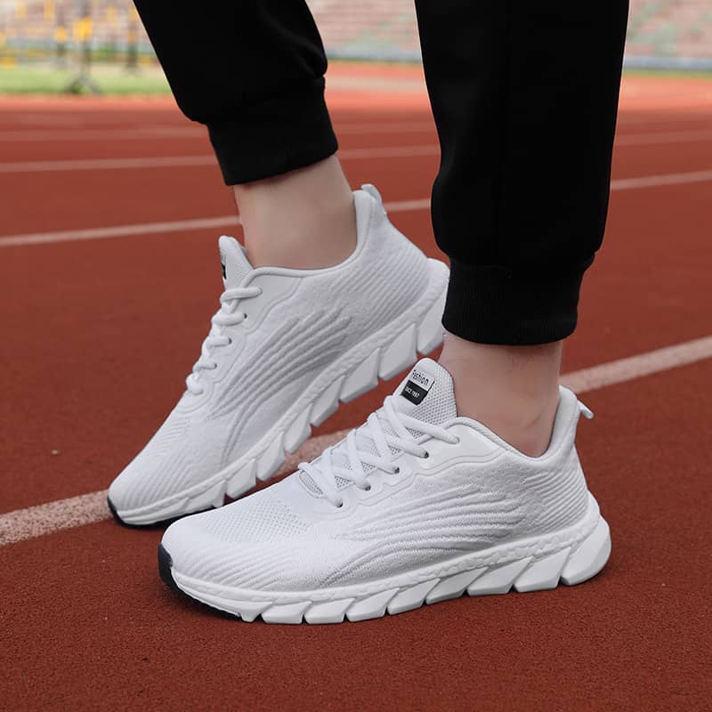 White running shoes on a person's feet on a track
