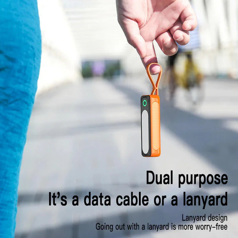 Orange dual-purpose data cable and lanyard held outdoors, portable tech accessory