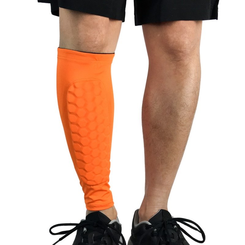 Person wearing bright orange leg sleeves on a white background
