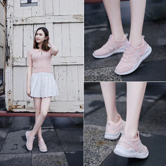 Woman wearing light pink athletic sneakers with white soles, styled with a skirt outdoors