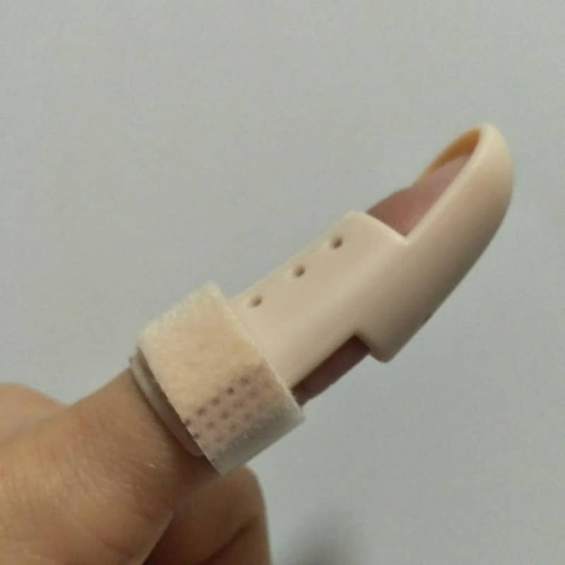 Beige finger splint on a person's finger against a plain background