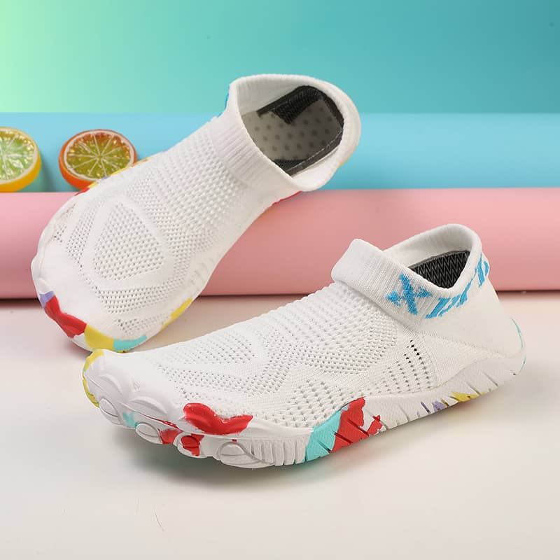 White slip-on shoes with colorful sole design on a light background
