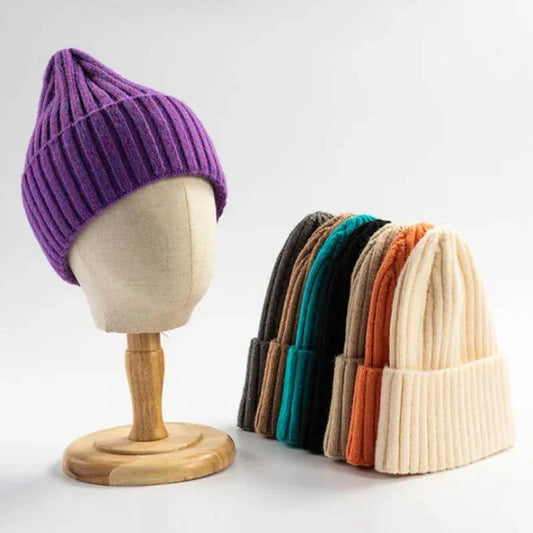 Assorted ribbed knit beanies in multiple colors, one displayed on a mannequin head